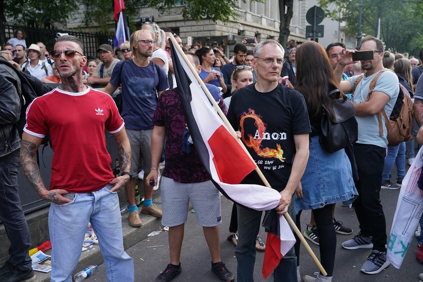 BERLIN, GERMANY - AUGUST 29: Mostly right-wing protesters, including a man wearing a QAnon shirt, face off against riot police on Unter den Linden avenue during protests against coronavirus-related re ...