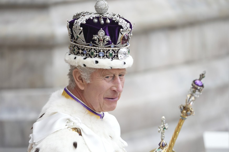 06.05.2023, Großbritannien, London: Großbritanniens König Charles III. verlässt nach der Krönungszeremonie mit der Imperial State Crown, einem Zepter und dem Reichsapfel die Westminster Abbey. Zur Krö ...