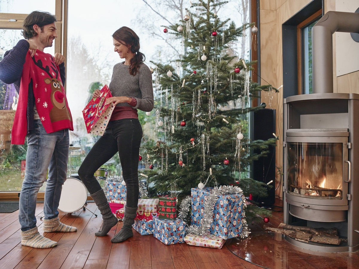 Couple standing in front of Christmas tree unwrapping Christmas jumper model released Symbolfoto property released PUBLICATIONxINxGERxSUIxAUTxHUNxONLY RHF001315

COUPLE thing in Front of Christmas Tre ...