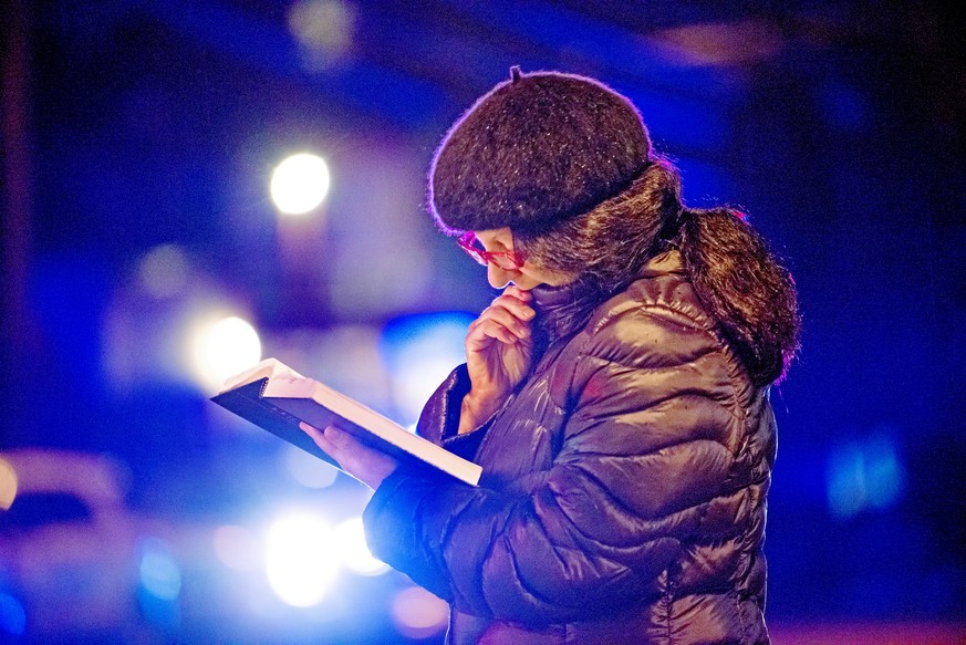 Nancy Clark of Squirrel Hill, reads from the Tehillim, as police lights flash and rain soaks the pages, yards away from Tree of Life Congregation, on Saturday, Oct. 27, 2018, in the Squirrel Hill sect ...