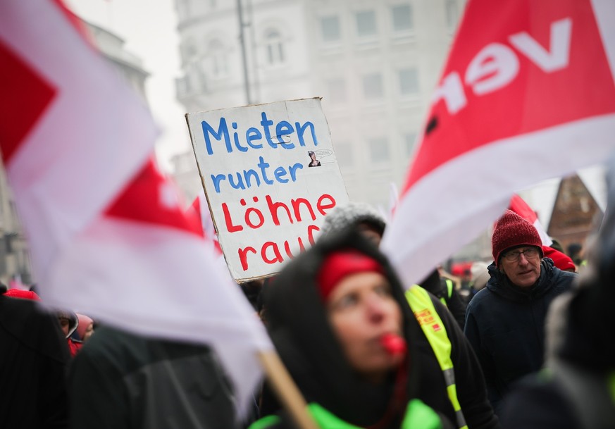 04.12.2023, Hamburg: &quot;Mieten runter - Löhne rauf&quot; steht auf einem Pappschild bei einer Demonstration der Gewerkschaft zur Finanzbehörde. Mit dem neuerlichen Warnstreik in verschiedenen Einri ...