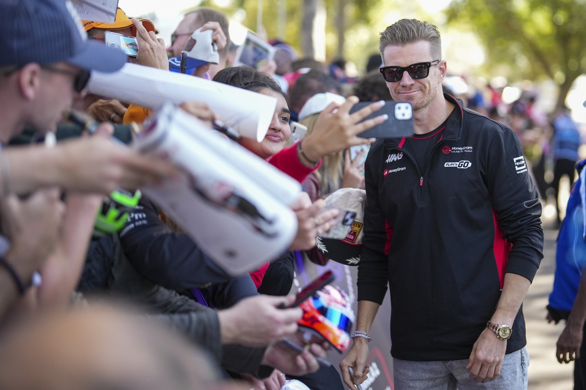 22.03.2024, Australien, Melbourne: Motorsport: Formel-1-Weltmeisterschaft, Grand Prix von Australien, 1. Freies Training. Der deutsche Haas-Pilot Nico Hülkenberg steht für ein Foto mit Fans zusammen, ...