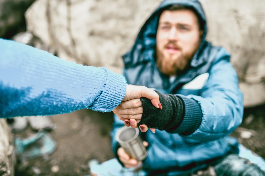 Homeless Male On The Street Getting Help From Female