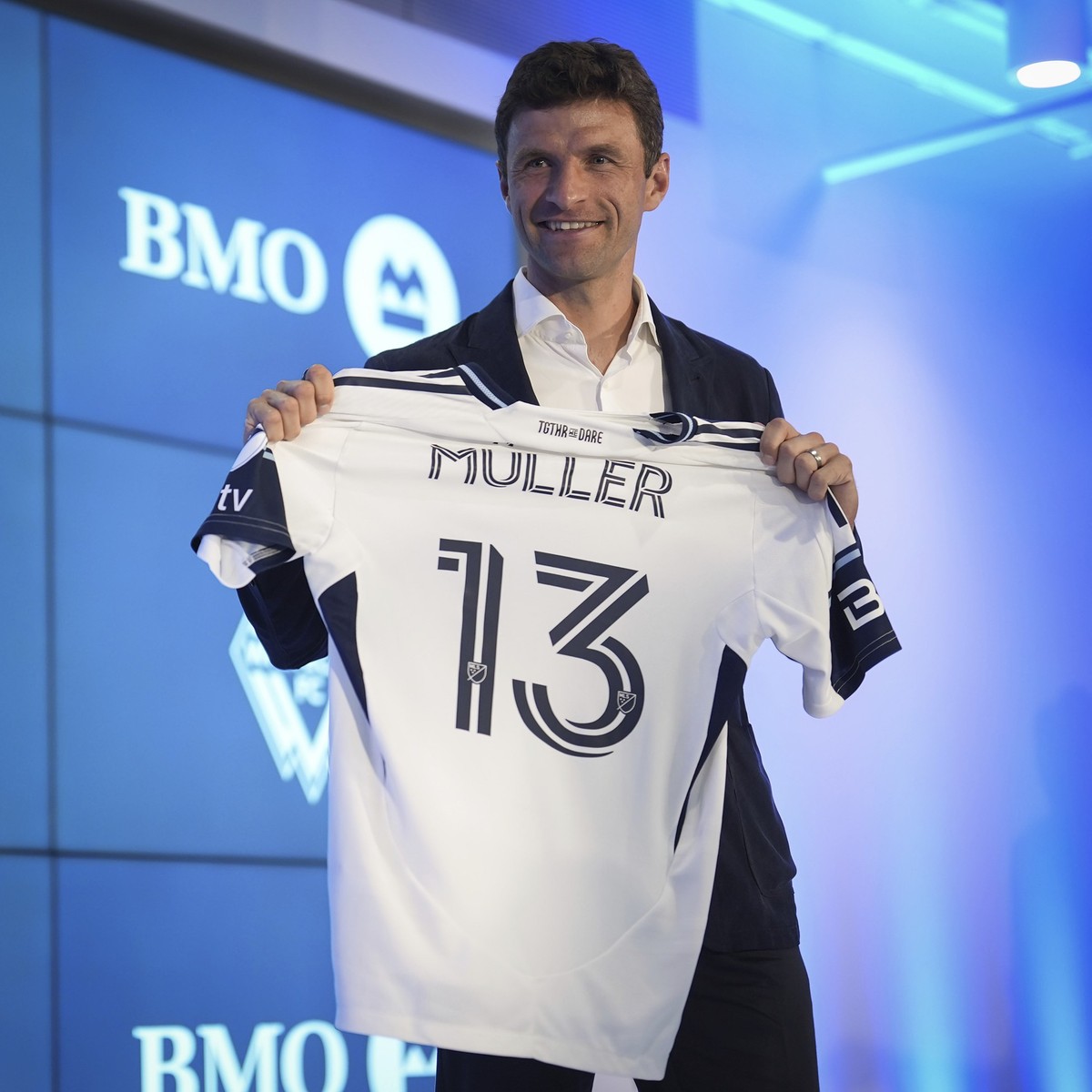 New Vancouver Whitecaps player Thomas Muller, of Germany, poses with his jersey during an MLS soccer news conference, Thursday, Aug. 14, 2025, in Vancouver, British Columbia. (Darryl Dyck/The Canadian ...