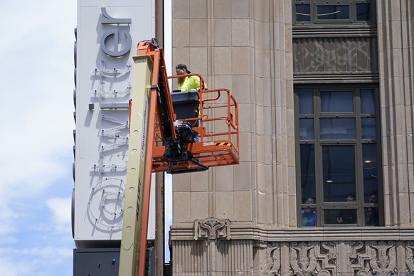 24.07.2023, USA, San Francisco: Arbeiter in der Twitter-Zentrale beobachten aus einem Fenster, wie ein Arbeiter das Twitter-Schild am Gebäude entfernt. Foto: Godofredo A. Vásquez/AP +++ dpa-Bildfunk + ...