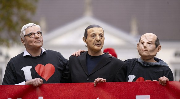 17.11.2023, Berlin: Vertreter der Gesellschaft f�r bedrohte V�lker protestieren anl�sslich des Besuches des t�rkischen Pr�sidenten Erdogan vor dem Schloss Bellevue und tragen dabei Masken mit den Gesi ...