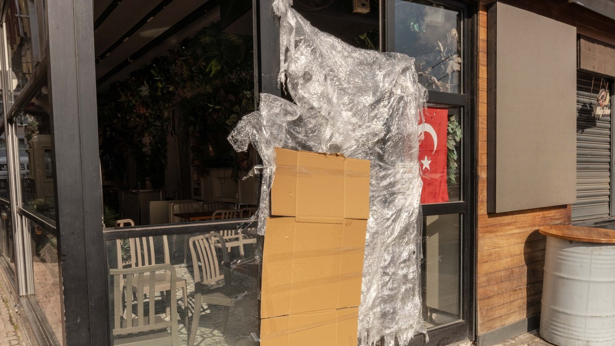 14.11.2025, Türkei, Istanbul: An einem türkischen Stand für Streetfood, der von den türkischen Behörden geschlossen wurde, hängen eine Pappe und eine Plastikplane neben einer türkischen Fahne. Streetf ...