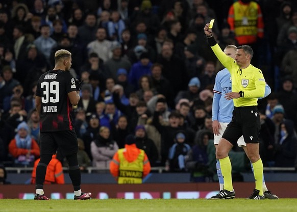 Manchester, England, 14th March 2023. Referee Slavic Vincic issues Benjamin Henrichs of RB Leipzig with a yellow card during the UEFA Champions League match at the Etihad Stadium, Manchester. Picture  ...