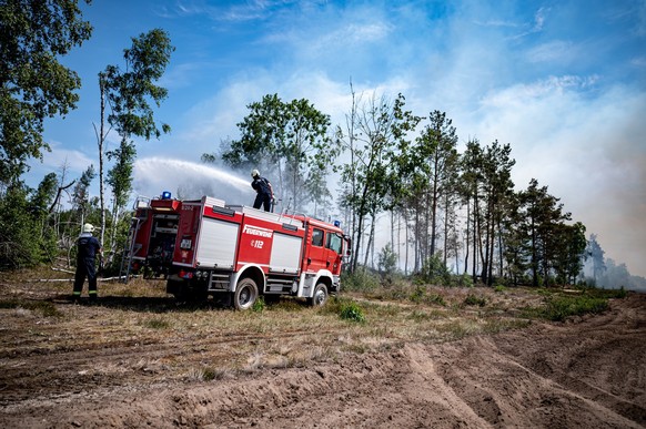 05.06.2023, Brandenburg, Jüterbog: Einsatzkräfte der Feuerwehr bekämpfen in einem Waldstück nahe Jüterbog das Feuer. Auffrischender Wind hat den Waldbrand in einem mit Munition belasteten Waldgebiet s ...