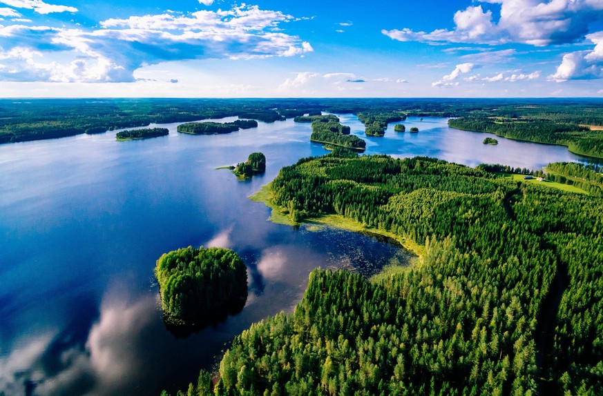 Aerial view of blue lakes and green forests on a sunny summer day in Finland. Drone photography from above