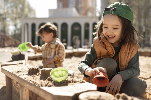 Smiling boy playing with sand on playground on sunny day model released, Symbolfoto, ANAF01374