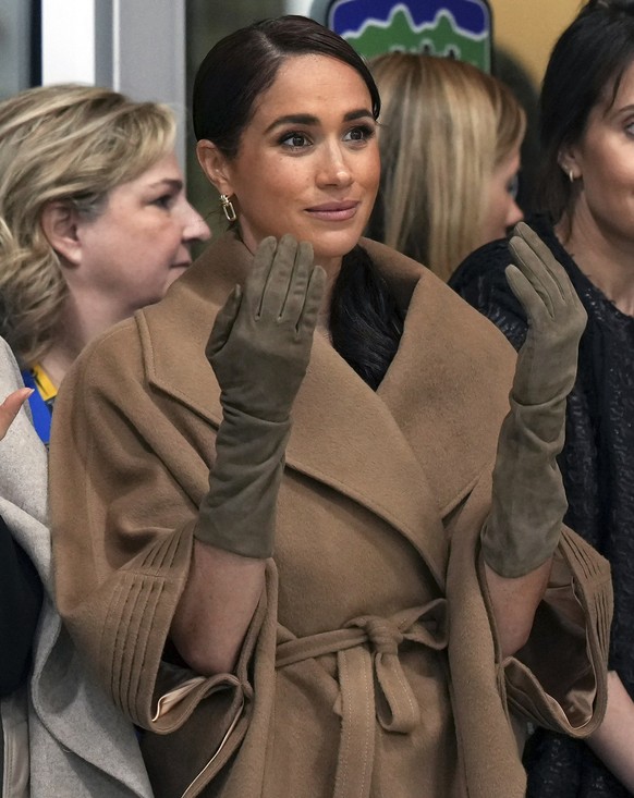 Meghan, Duchess of Sussex, raises her hands after a First Nations welcome during an Invictus Games wheelchair curling training camp in Vancouver, British Columbia, Friday, Feb. 16, 2024. (Darryl Dyck/ ...