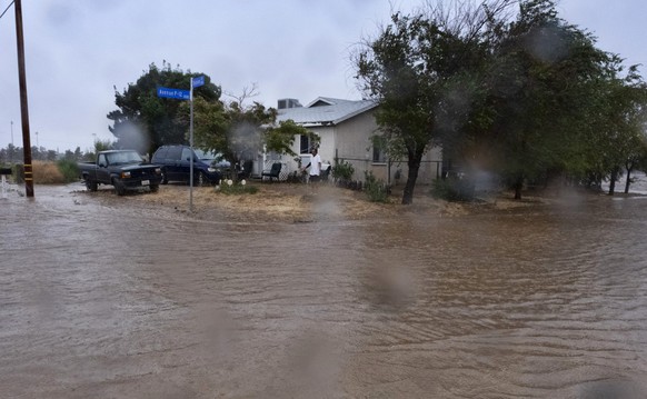 20.08.2023, USA, Palmdale: Ein Anwohner prüft während eines Regengusses die Überschwemmungen rund um sein Haus, als der Tropensturm «Hilary» auf das Gebiet zusteuert. Der Pazifik-Tropensturm «Hilary»  ...