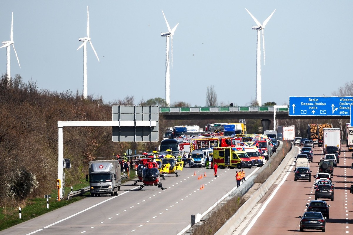 27.03.2024, Sachsen, Schkeuditz: Einsatzfahrzeuge und Rettungshubschrauber stehen auf der A9 an der Unfallstelle. Bei einem Unfall mit einem Reisebus auf der A9 bei Leipzig ist mindestens ein Mensch u ...