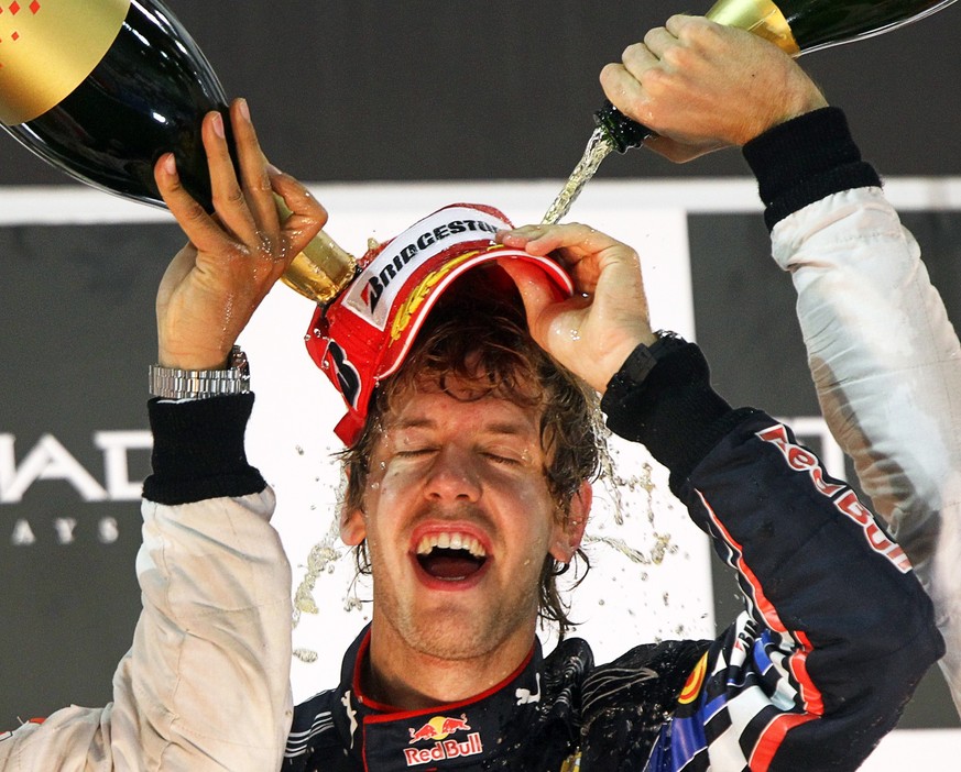 ARCHIV - 14.11.2010, Vereinigte Arabische Emirate, Abu Dhabi: Der deutsche Formel 1 Rennfahrer Sebastian Vettel vom Team Red Bull feiert auf dem Yas Marina Circuit nach seinem Sieg in der Formel-1-Wel ...