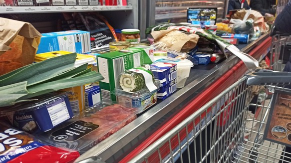 Einkauf in einem Supermarkt oder Discounter zu Zeiten von Corona und Krieg in der Ukraine. Preisvergleich, Teuerung, Grundnahrungsmittel, Kasse, Kassenbereich, Inflation, Lebensmittel, Einkauf in Zeit ...