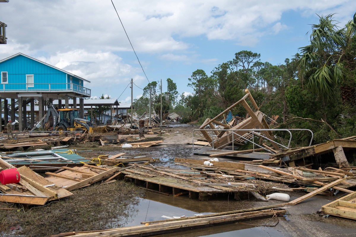 U.S. Airmen assigned to the 202nd Rapid Engineer Deployable Heavy Operational Repair Squadron Engineers RED HORSE Squadron, Florida Air National Guard, clear roads in Keaton Beach, Florida, on Friday, ...