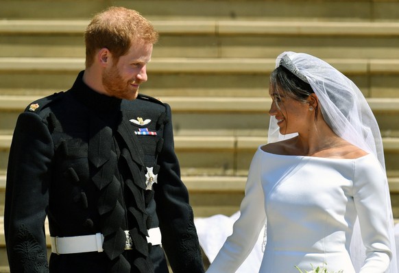 FILE - Prince Harry and Meghan Markle walk down the steps after their wedding at St. George&#039;s Chapel in Windsor Castle in Windsor, near London, England, Saturday, May 19, 2018. Britain’s monarchy ...