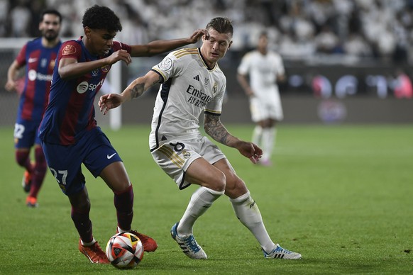 Real Madrid&#039;s Toni Kroos, right, fights for the ball with Barcelona&#039;s Lamine Yamal during the Spanish Super Cup final soccer match between Real Madrid and Barcelona at Al Awwal Park Stadium  ...