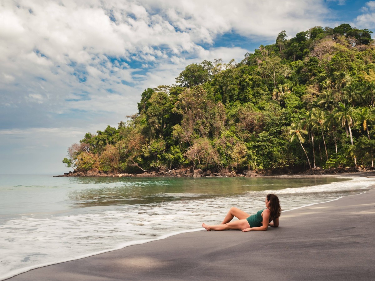 Woman in swimsuit laying on empty sandy beach in Costa Rica. Quepos, Provincia de Puntarenas, Costa Rica CR_DOHO250307C-1674894-01 ,model released, Symbolfoto