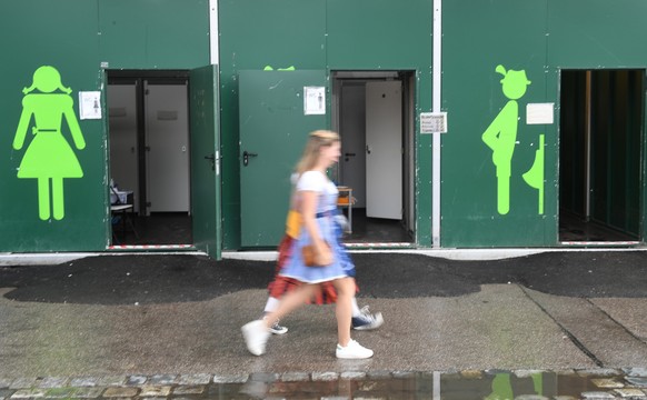 26.09.2022, Bayern, M�nchen: Zwei Damen gehen an Toiletten auf dem Oktoberfest vorbei. Die Wiesn findet vom 17. September bis 3. Oktober 2022 statt. Foto: Felix H�rhager/dpa +++ dpa-Bildfunk +++