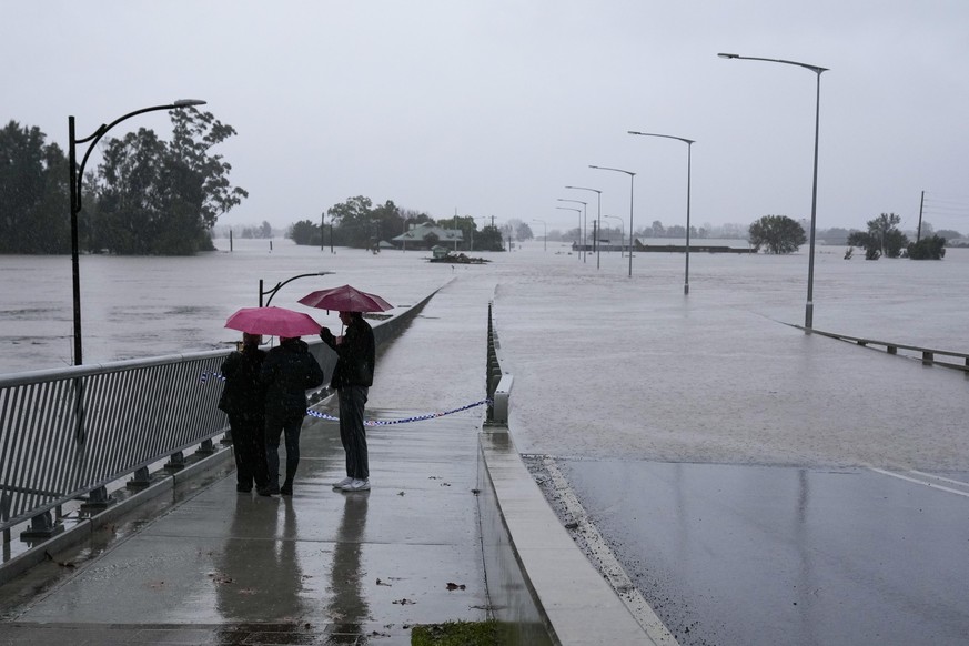 People look at the flooded Windsor Bridge on the outskirts of Sydney, Australia, Monday, July 4, 2022. More than 30,000 residents of Sydney and its surrounds have been told to evacuate or prepare to a ...