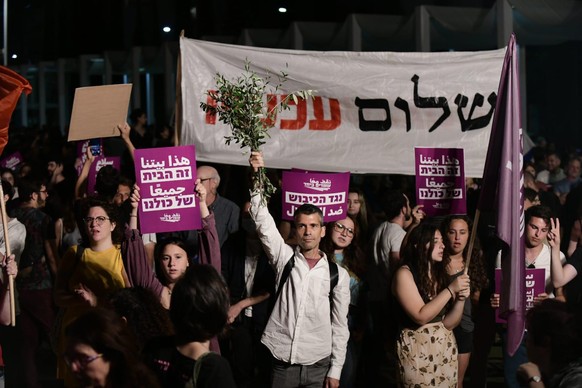 Demo für Frieden: Ein Demonstrant von "Standing Together" mit einem Büschel Olivenzweige in Tel Aviv.