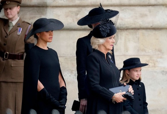 LONDON, ENGLAND - SEPTEMBER 19: Meghan, Duchess of Sussex, Camilla, Queen Consort and Princess Charlotte of Wales watch on as The Queen's funeral cortege borne on the State Gun Carriage of the Ro ...