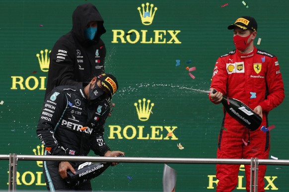 Third placed Ferrari driver Sebastian Vettel of Germany, right, pours champagne of race winner Mercedes driver Lewis Hamilton of Britain on the podium of the Formula One Turkish Grand Prix at the Ista ...