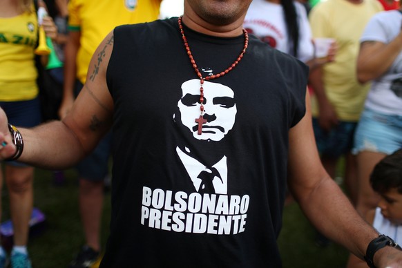 A supporter of Jair Bolsonaro, far-right lawmaker and presidential candidate of the Social Liberal Party (PSL), wears a T-shirt with an image of Bolsonaro, during a runoff election, in Rio de Janeiro, ...