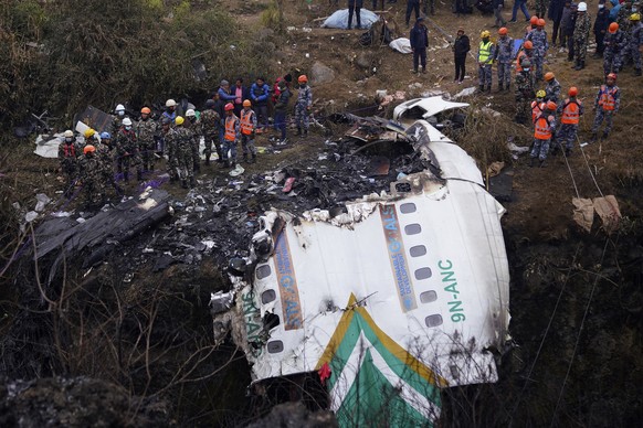 16.01.2023, Nepal, Pokhara: Rettungskräfte durchsuchen die Absturzstelle im Wrack eines Passagierflugzeugs. Nach dem Flugzeugabsturz in Nepal mit Dutzenden Toten geht die Suche nach den letzten Insass ...