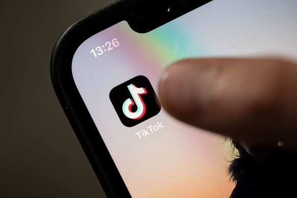 ARCHIV - 11.07.2022, Baden-Württemberg, Stuttgart: Ein Teenager tippt auf das Icon TikTok-App auf einem Smartphone. Die italienische Wettbewerbsbehörde hat eine Untersuchung gegen die Videoplattform T ...