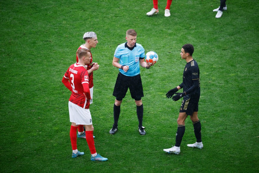 Fußball: Bundesliga, SC Freiburg - Bayern München, 28. Spieltag, Europa-Park Stadion: Freiburgs Philipp Lienhart (l-r), Freiburgs Nico Schlotterbeck, Schiedsrichter Christian Dingert, Münchens Jamal M ...