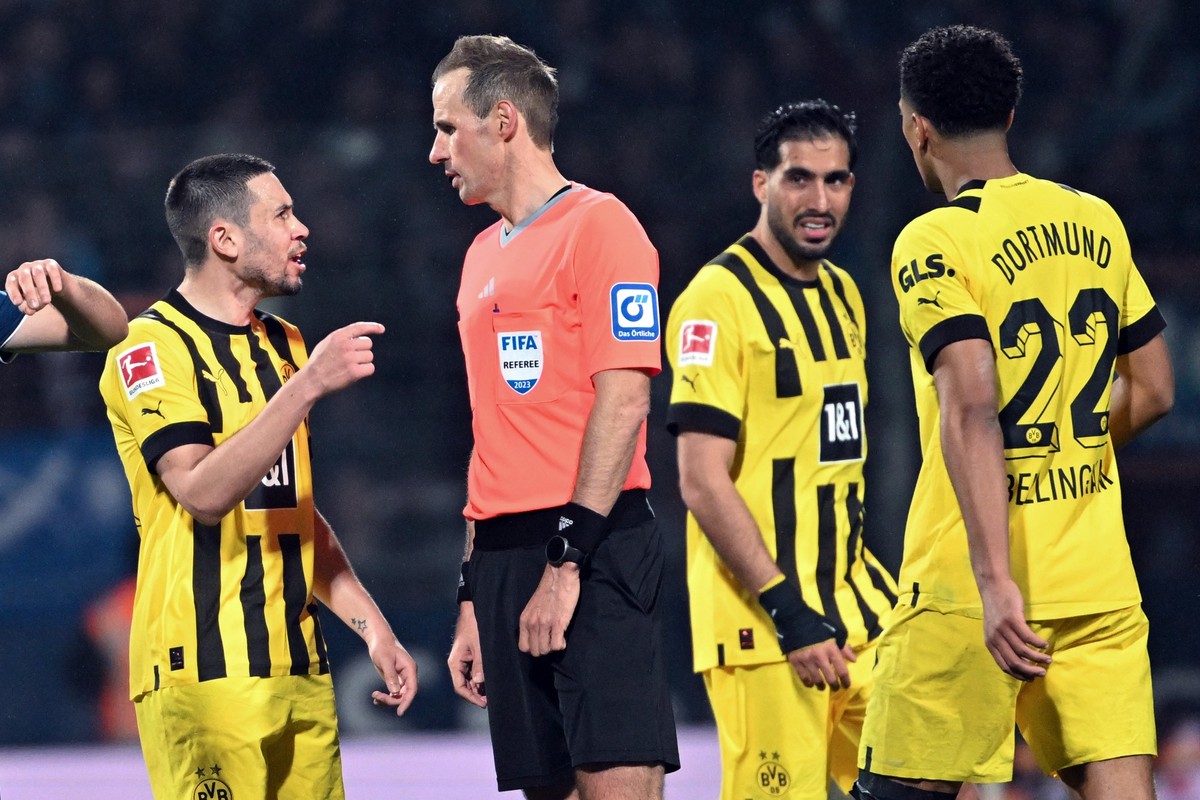 28.04.2023, Nordrhein-Westfalen, Bochum: Fußball: Bundesliga, VfL Bochum - Borussia Dortmund, 30. Spieltag, im Vonovia Ruhrstadion. Dortmunds Raphael Guerreiro (l-r), Emre Can (M) und Jude Bellingham  ...