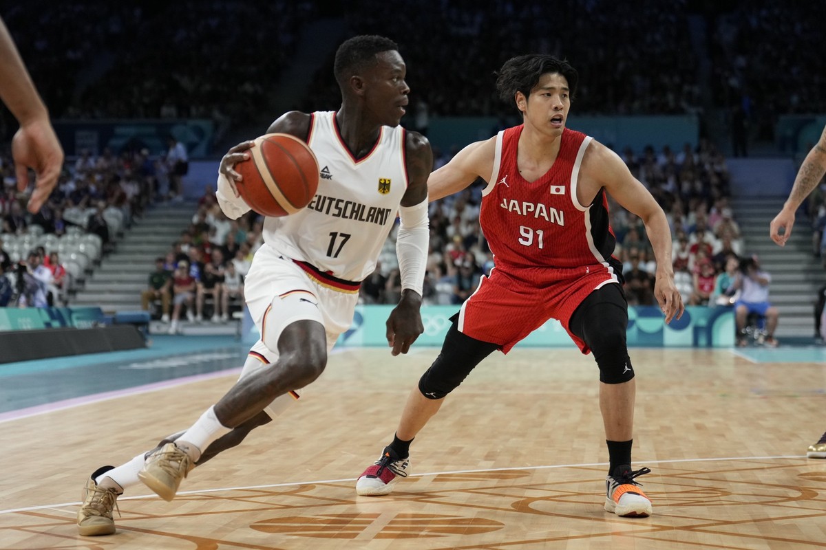 27.07.2024, Frankreich, Villeneuve-d'Ascq: Olympia, Paris 2024, Basketball: Olympia, Deutschland - Japan, Deutschlands Dennis Schröder (l) und Hirotaka Yoshii aus Japan kämpfen um den Desk. Foto: ...