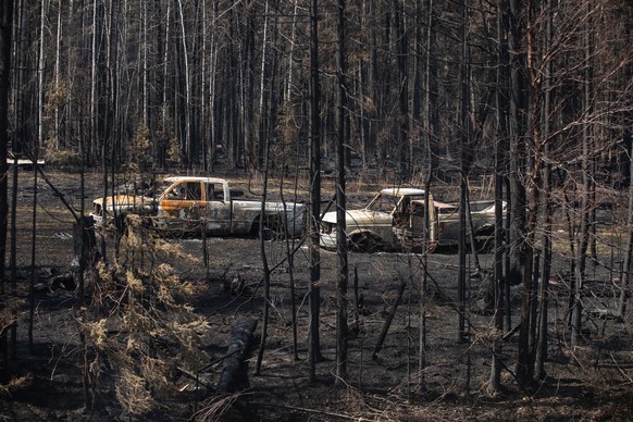 10.05.2023, Kanada, Drayton Valley: Ausgebrannte PickUps stehen nach einem Waldbrand auf einem Grundst�ck in der N�he von Drayton Valley. Dutzende Waldbr�nde hatten im Westen Kanadas Tausende Menschen ...