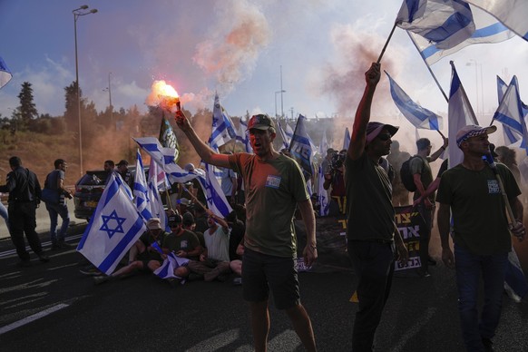 Demonstrators block a highway leading to Jerusalem, during a protest against plans by Prime Minister Benjamin Netanyahu&#039;s new government to overhaul the judicial system, Tuesday, July 11, 2023. I ...