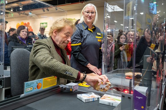 23.11.2022, Bayern, Regensburg: Thomas Gottschalk, Entertainer, sitzt an einer Supermarkt-Kasse. Das Geld aus der Aktion kommt den Angaben nach �ber die Netto Marken-Discount Stiftung verschiedenen so ...