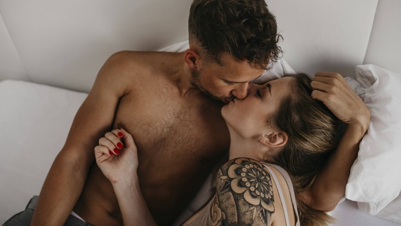 Romantic young couple kissing in bed model released Symbolfoto property released PUBLICATIONxINxGERxSUIxAUTxHUNxONLY LHPF00026