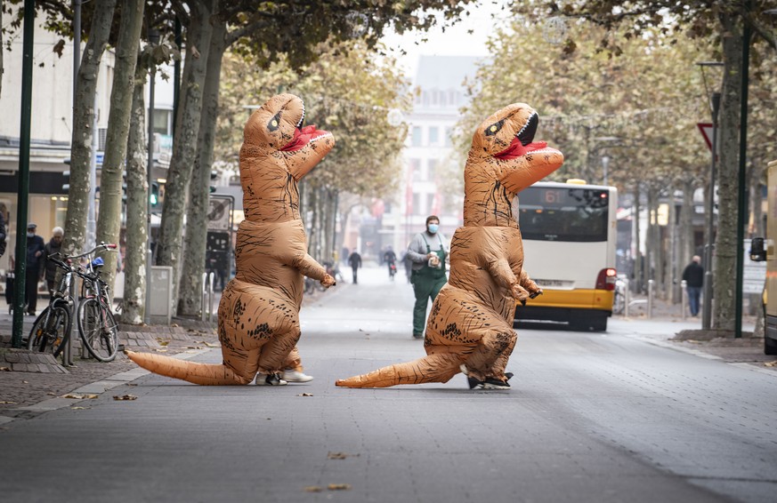 11.11.2020, Rheinland-Pfalz, Mainz: Zwei Karnevalistinnen in aufblasbaren Dinosaurier-Kost