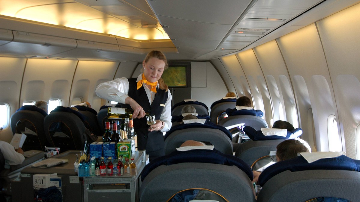 Lufthansa-Flugbegleiterin serviert den Passagieren der Business Class Getr