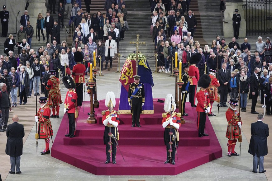 FILE - Members of the public file past as King Charles III, Princess Anne, Prince Andrew and Prince Edward hold a vigil beside the coffin of their mother, Queen Elizabeth II, as it lies in state on th ...