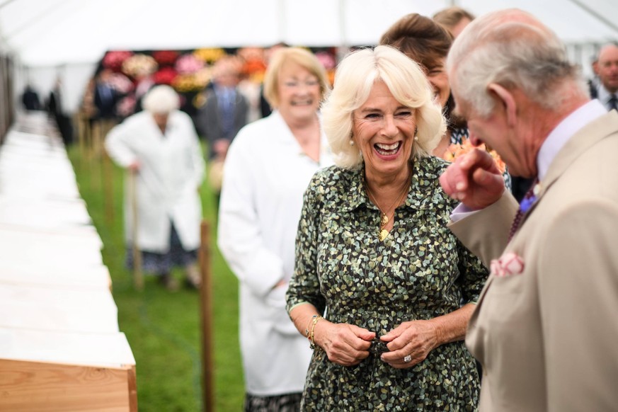 Britain s King Charles III R and Britain s Queen Camilla L laugh together during a visit of the Sandringham Flower Show, in Sandrigham, north west England, on July 26, 2023., Credit:DANIEL LEAL / Aval ...
