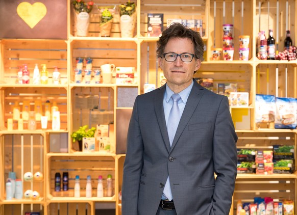 17 April 2018, Hamburg, Germany: Markus Mosa, CEO of the Edeka AG, standing in front of the laboratory of ideas of the company&#039;s headquarters in front of a decorated wall with groceries and produ ...