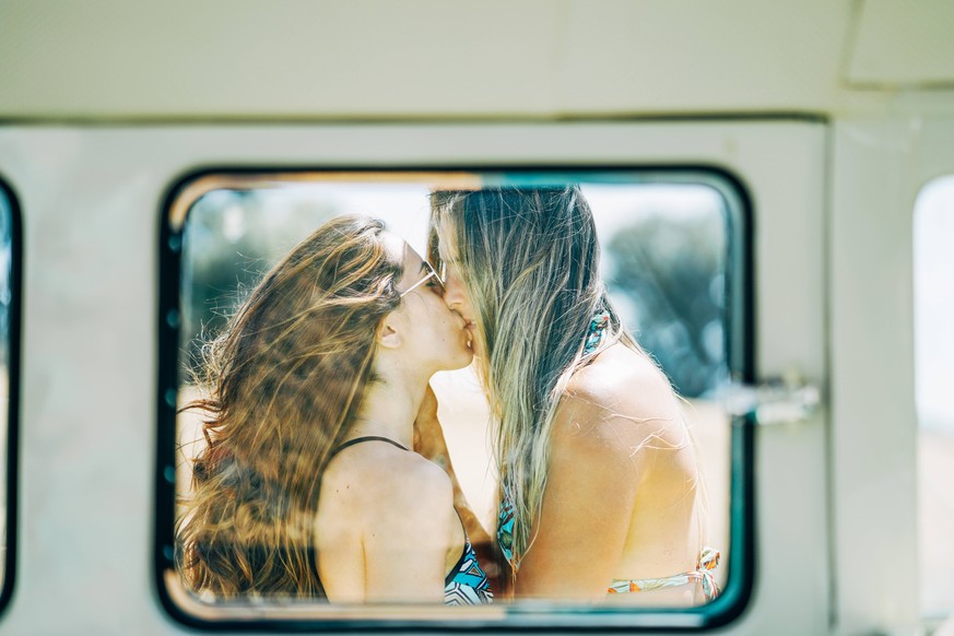 Lesbian couple doing a road trip, kissing and embracing in nature model released Symbolfoto PUBLICATIONxINxGERxSUIxAUTxHUNxONLY OCMF00083