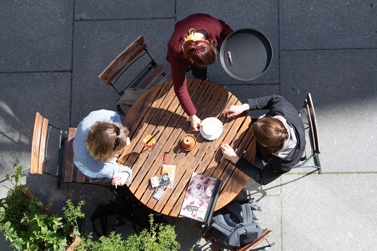 ARCHIV - 15.05.2020, Sachsen, Dresden: Eine Kellnerin bedient in einem Cafe zwei Frauen. Jeder vierte sozialversicherungspflichtig Besch