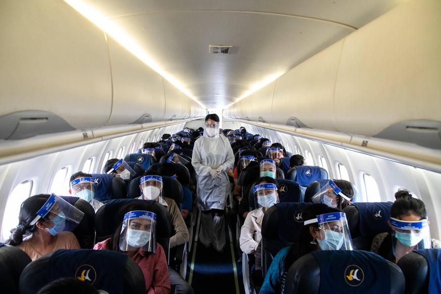July 3, 2020, Kathmandu, Nepal: An air hostess of Buddha Air wearing a protective suit attends to passengers inside the aircraft during a mock safety drill to make necessary preparations for the resum ...