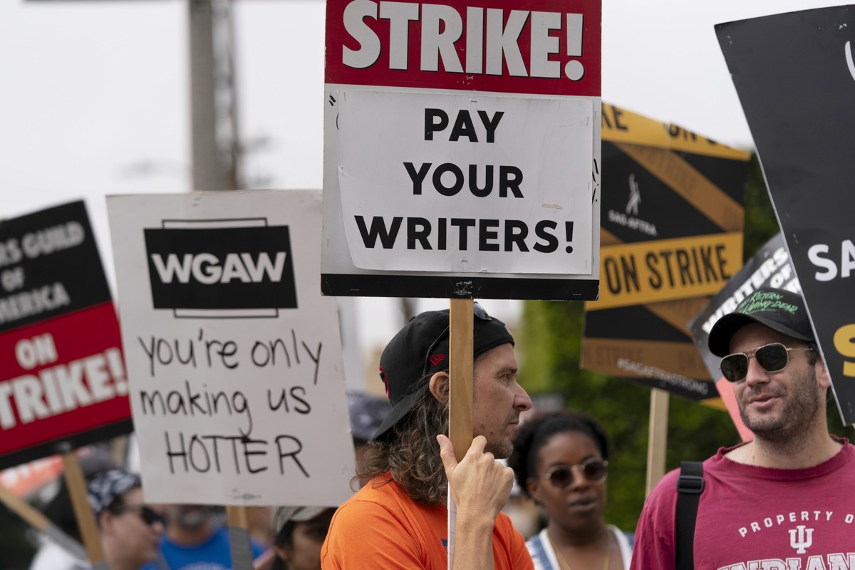 21.09.2023, USA, Los Angeles: Demonstranten halten Plakate während einer Kundgebung vor dem Paramount Pictures Studio. Die laufenden Verhandlungen in Hollywood zwischen den Studios und der Gewerkschaf ...