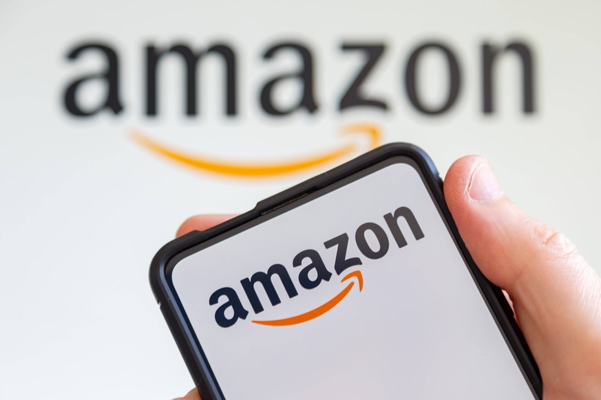 Hand h�lt Handy mit Amazon Logo Online-Marktplatz Onlinehandel Ecommerce Computer Bildschirm Stuttgart, Deutschland - 20. Juli 2023: Hand h�lt Handy mit Amazon Logo Online-Marktplatz Onlinehandel Ecom ...