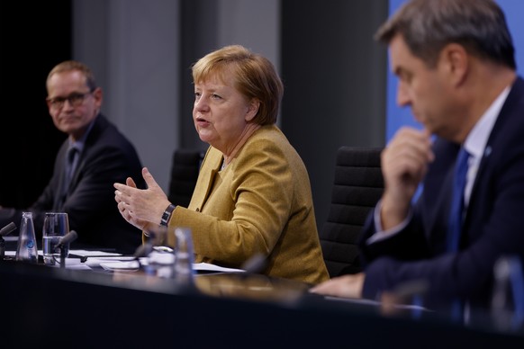 25.11.2020, Berlin: Bundeskanzlerin Angela Merkel (CDU) spricht im Bundeskanzleramt in der Pressekonferenz neben Bayerns Ministerpr�sident Markus Soeder (CSU - r) und Berlins�Regierendem B�rgermeister ...